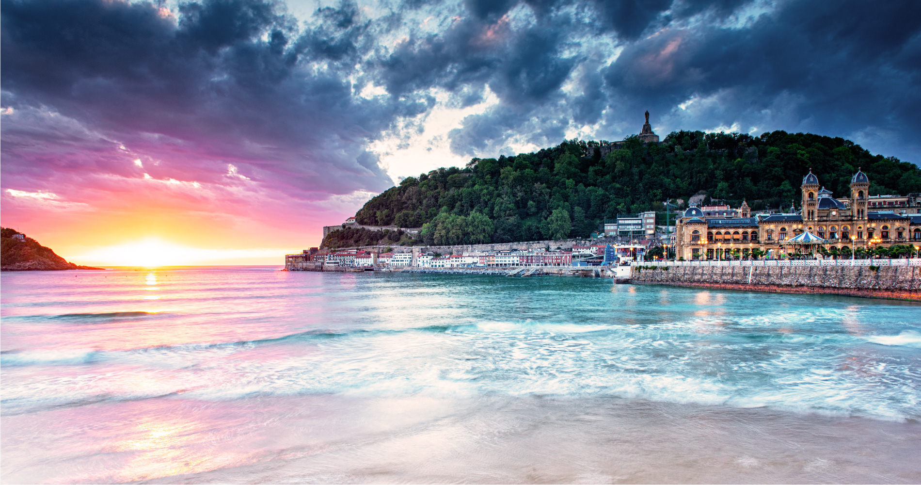 Beach at San Sebastian overlooking sunset and town. Spanish style architecture